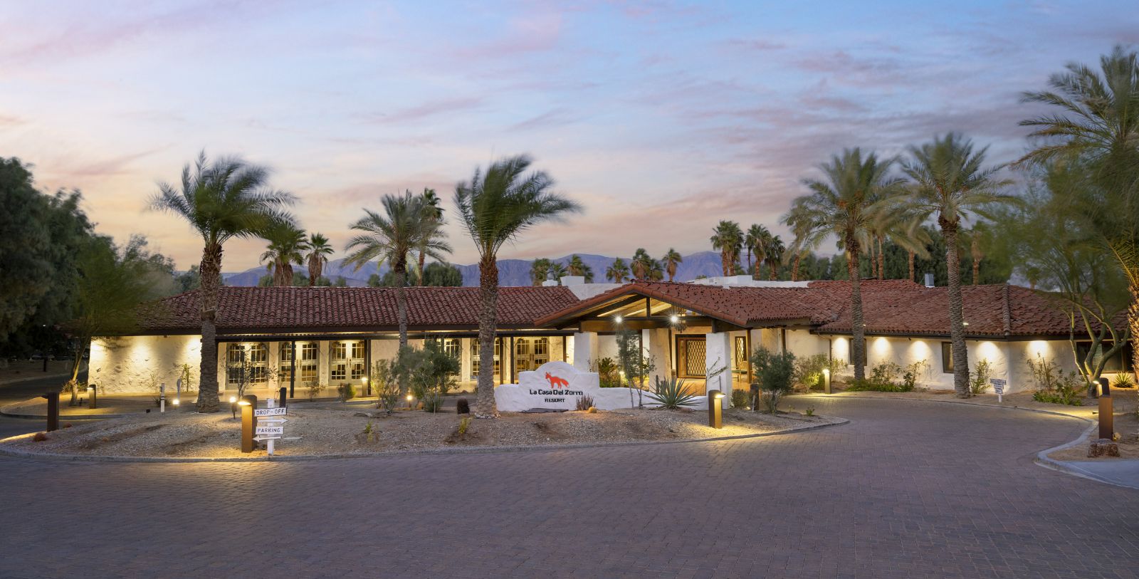 a building with palm trees and a sign