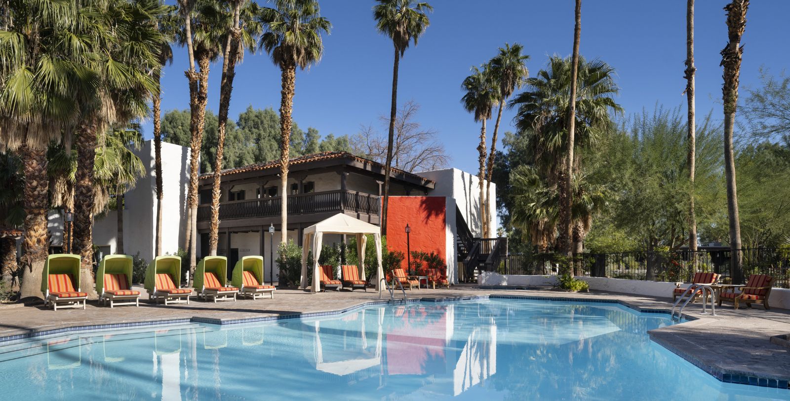 a pool with lounge chairs and palm trees