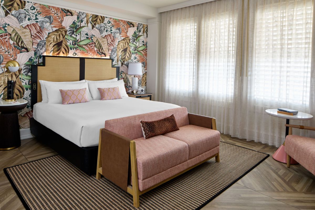 a bed with a pink couch in a room with white curtains