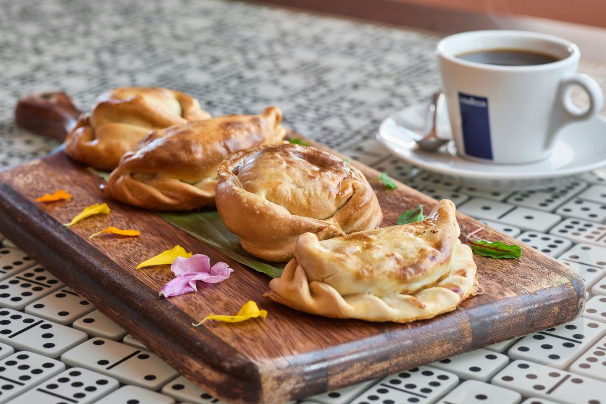 food on a wooden board next to a cup of coffee