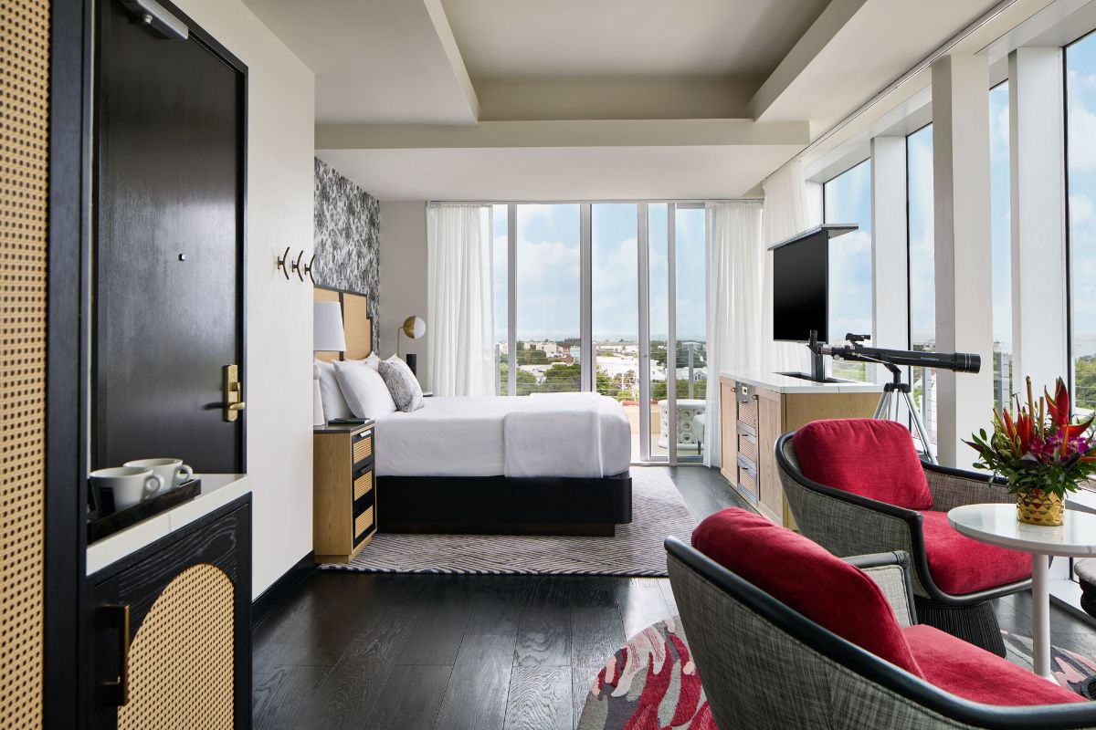 a room with a bed and chairs