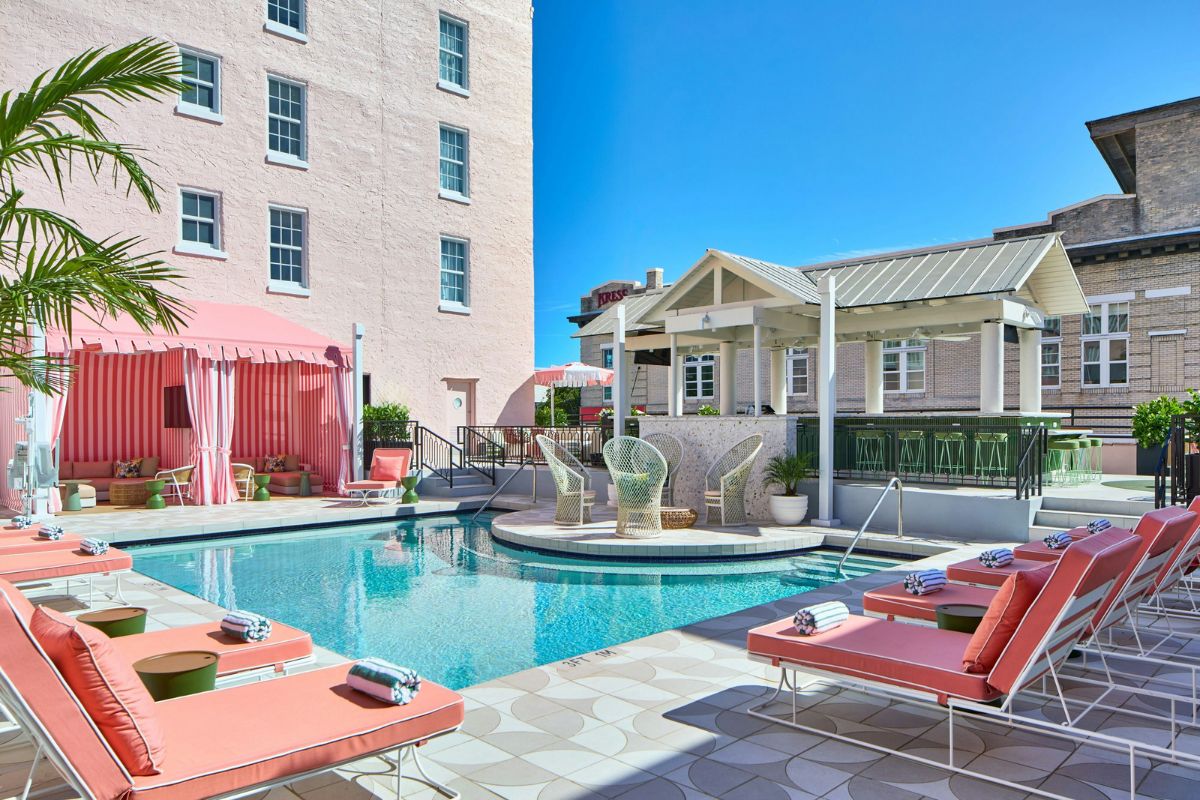 a pool with chairs and a building