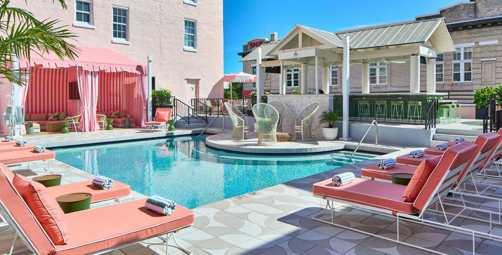 a pool with chairs and a building