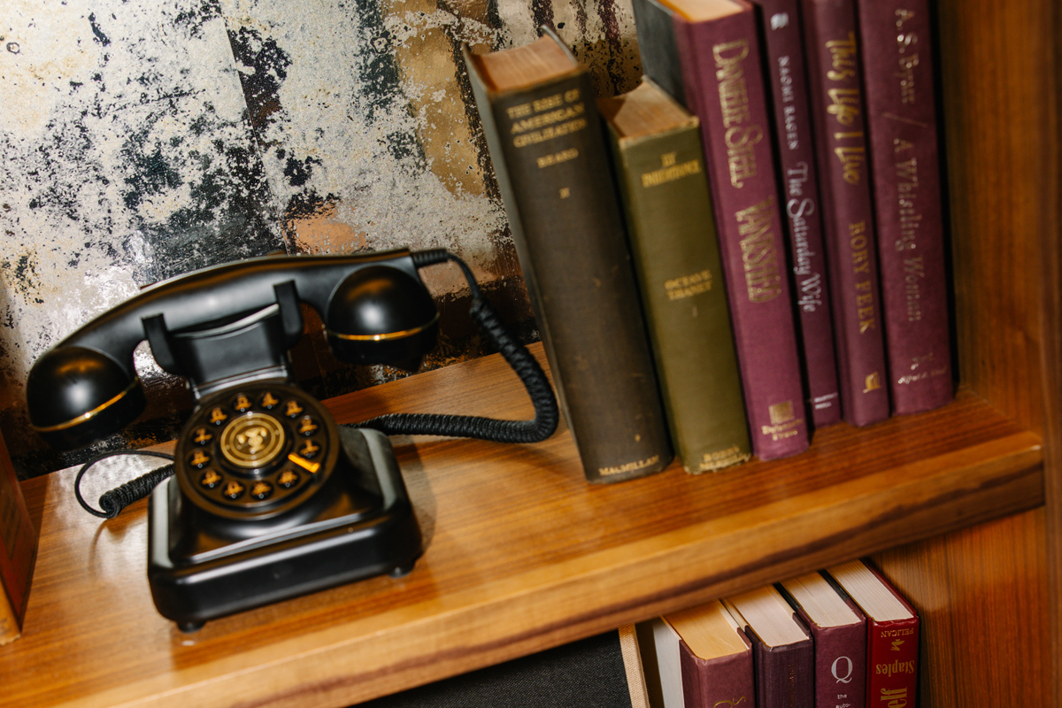a telephone and books on a shelf