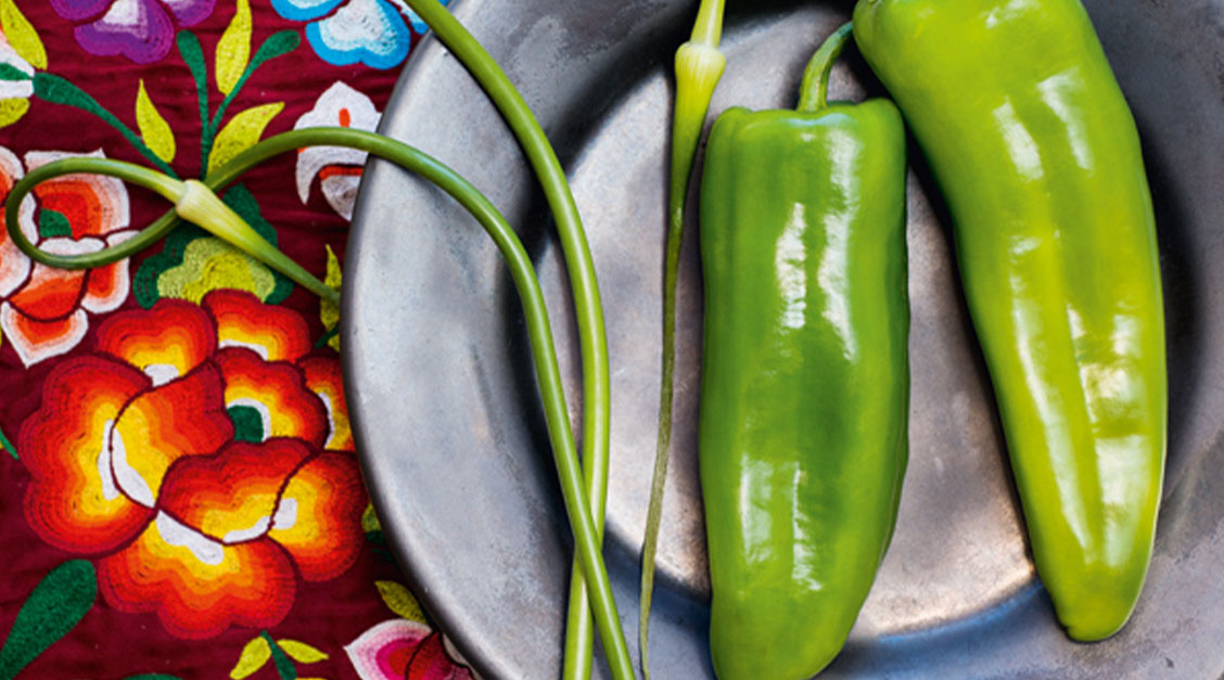 a green peppers and long stems on a plate