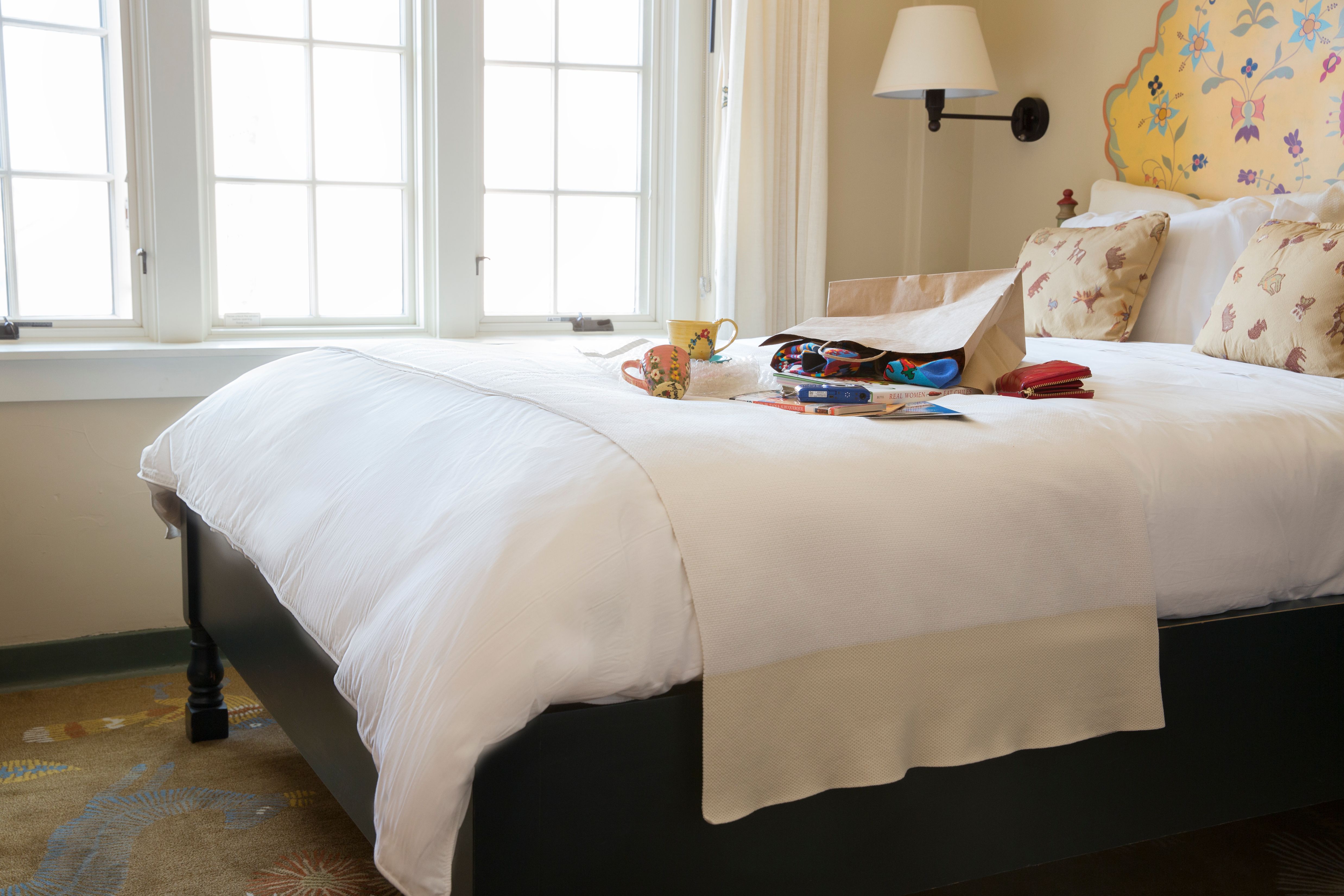 a bed with a bag and a cup on it