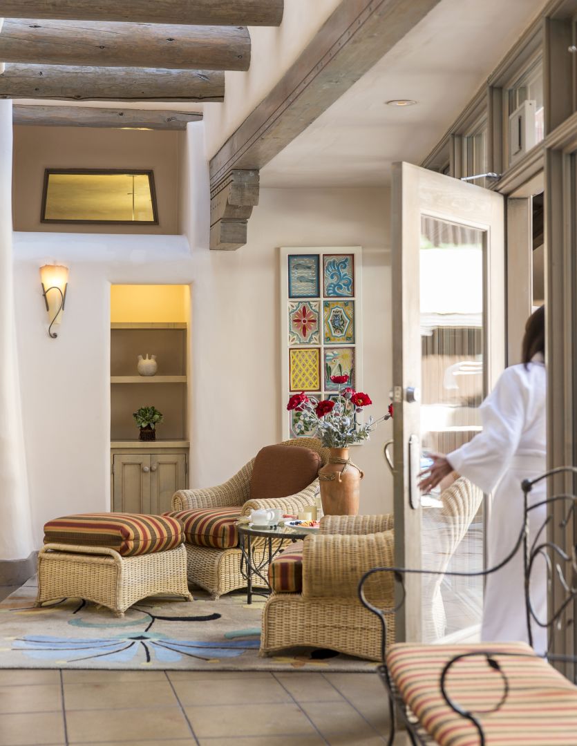 a room with a glass door and wicker furniture