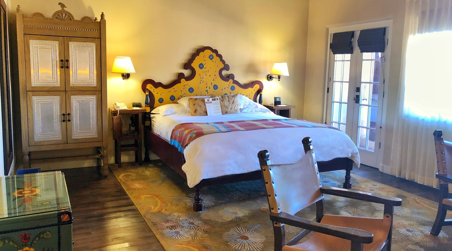 a bed with a yellow headboard and a wood floor