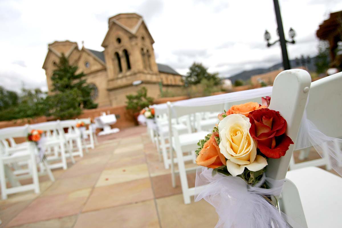 a wedding ceremony with white chairs and flowers