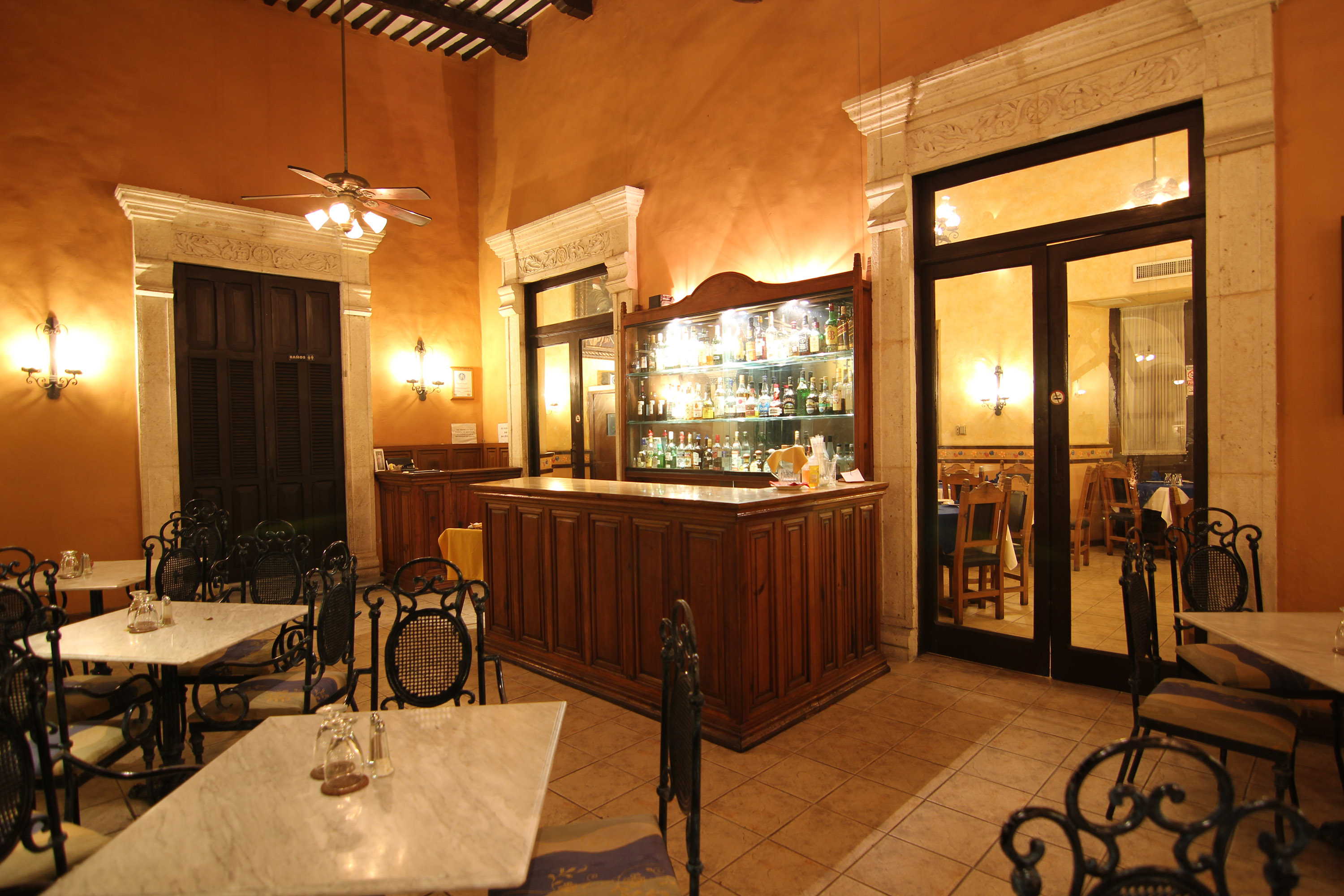 a room with a bar and tables