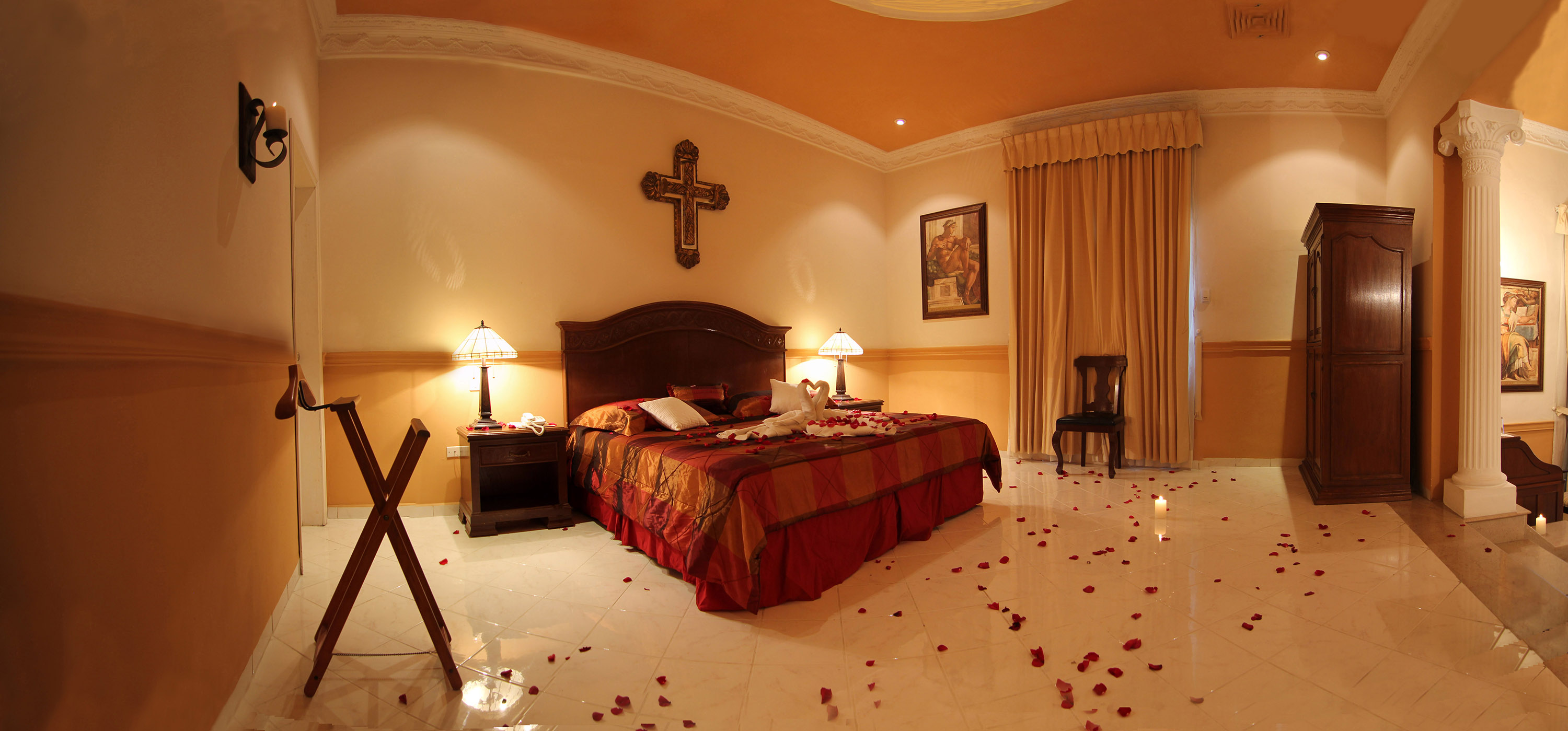 a bedroom with a bed and rose petals on the floor