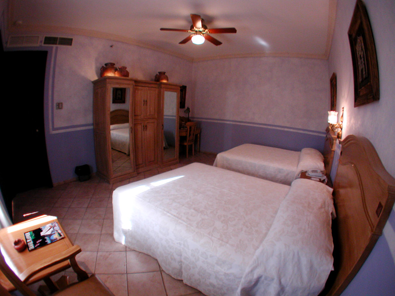 a room with two beds and a ceiling fan