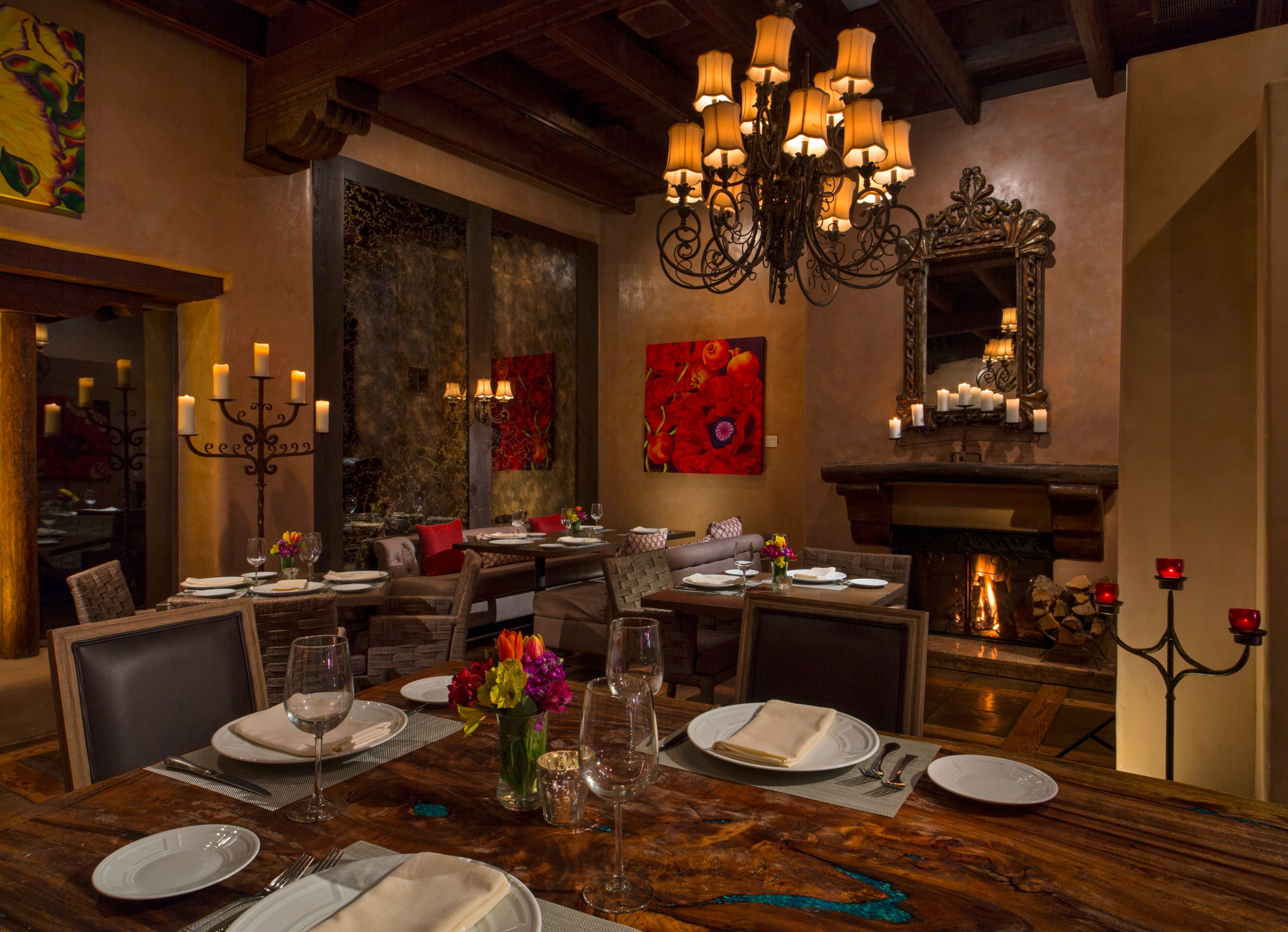 a room with a chandelier and tables and chairs