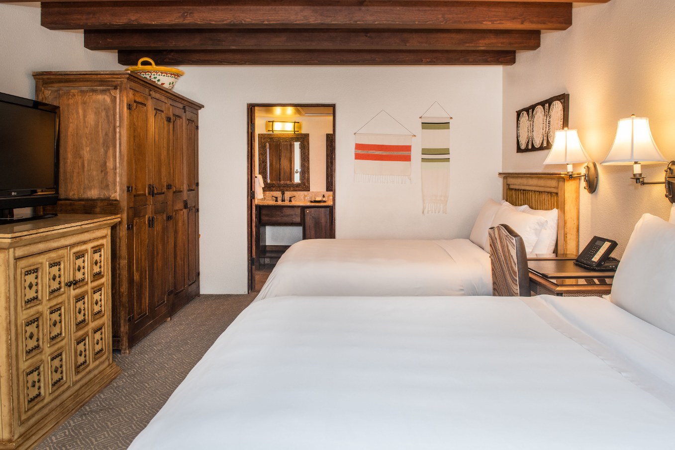 a room with two beds and a wood cabinet