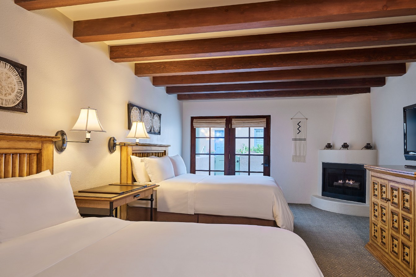 a room with two beds and a fireplace