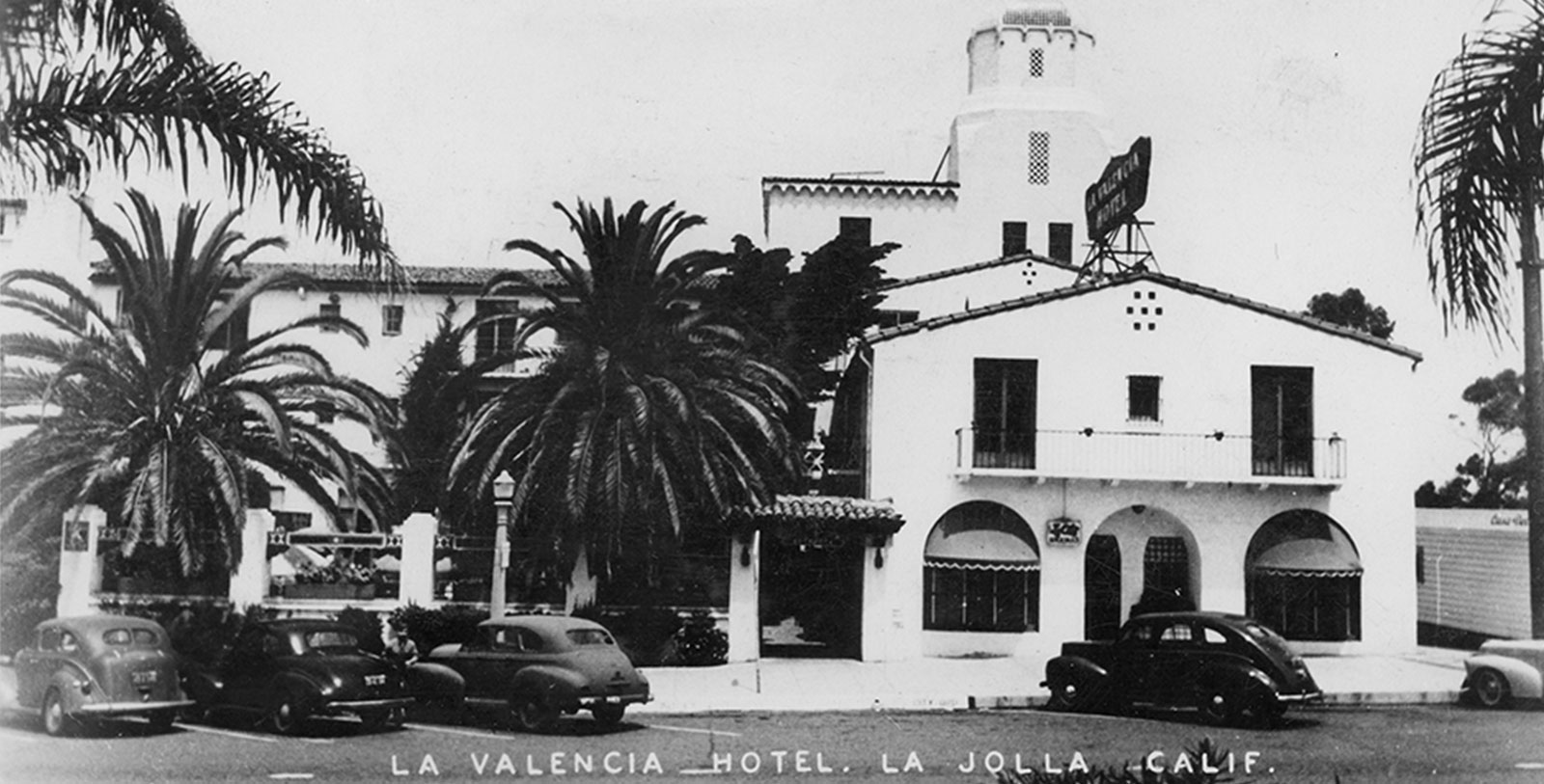 a building with palm trees and a building with a tower