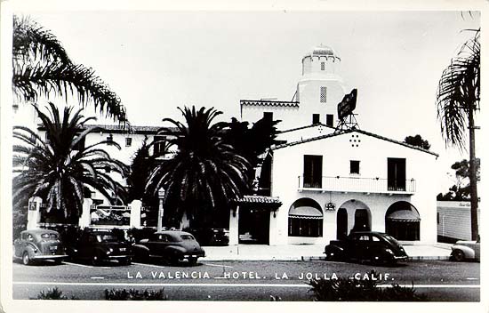 a hotel with palm trees and cars