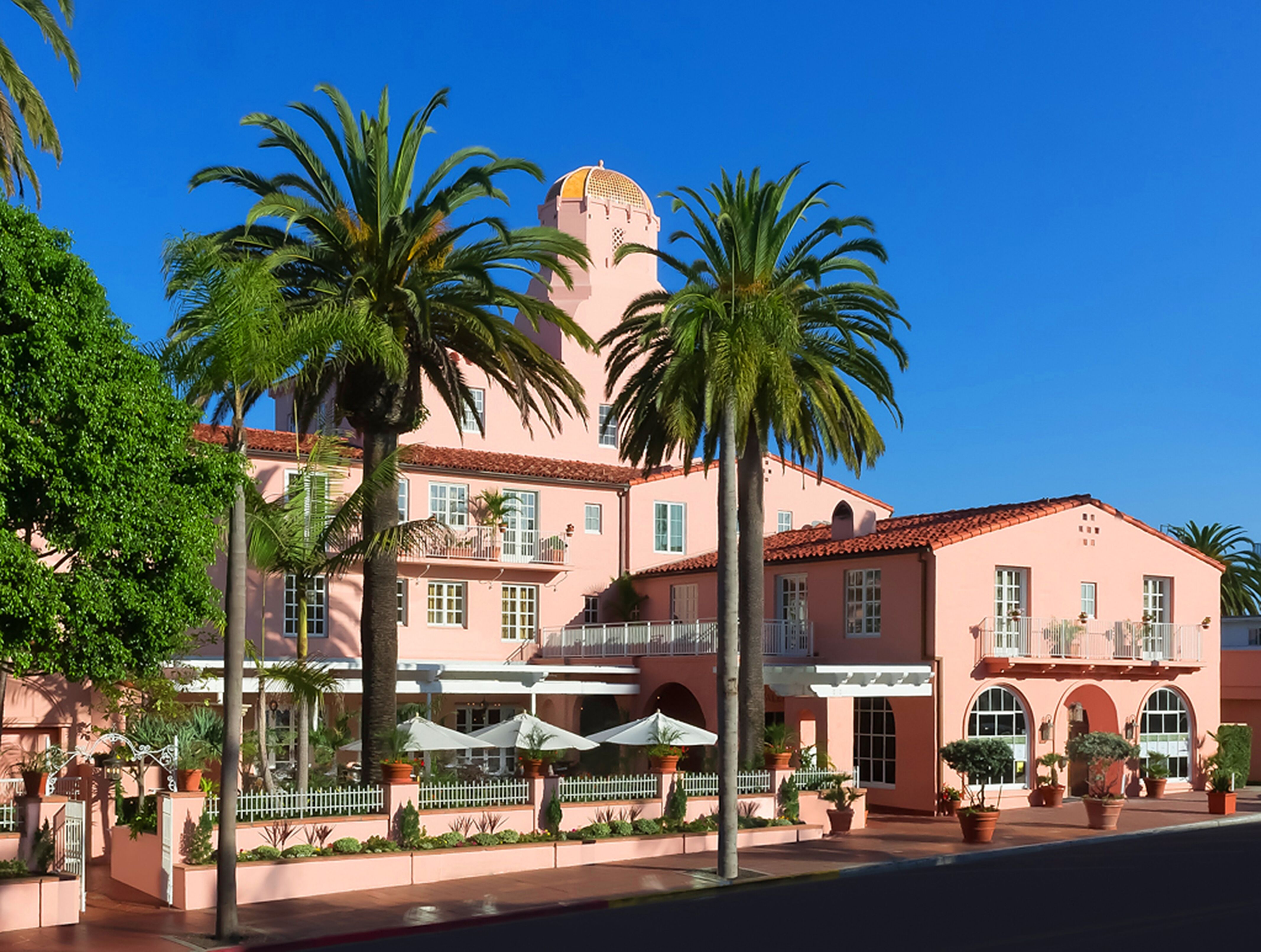 a pink building with palm trees