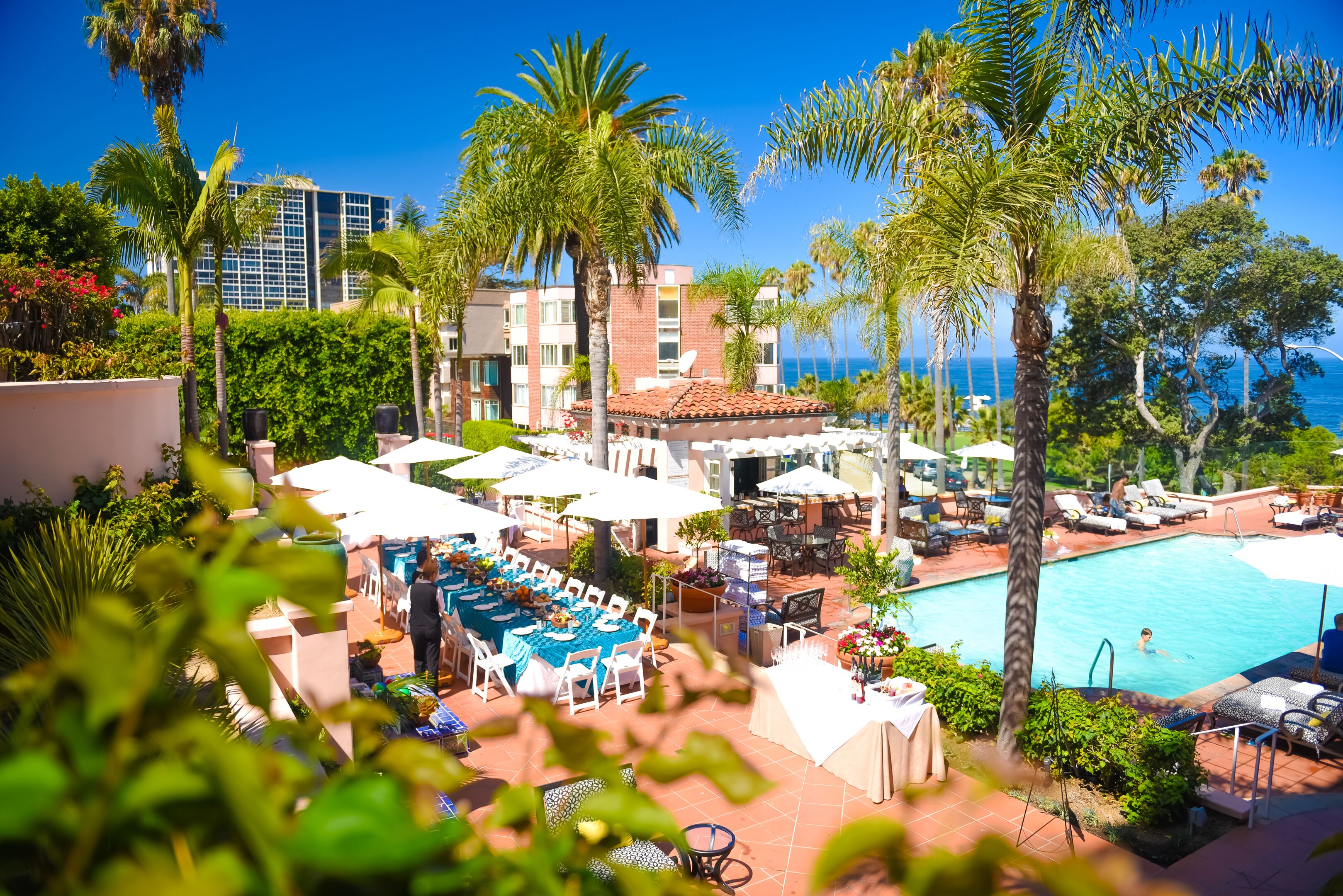 a pool with tables and chairs and palm trees