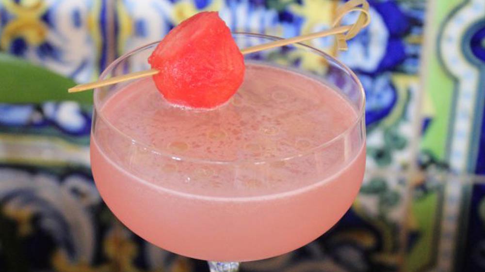 a glass with a drink and a watermelon on it