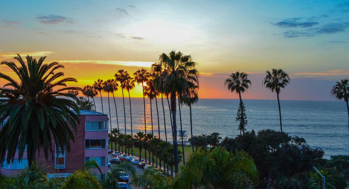 a sunset over a beach with palm trees