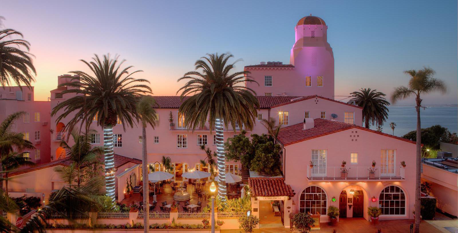 a pink building with palm trees