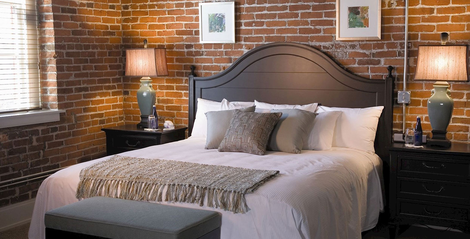 a bed with pillows and a lamp on the side
