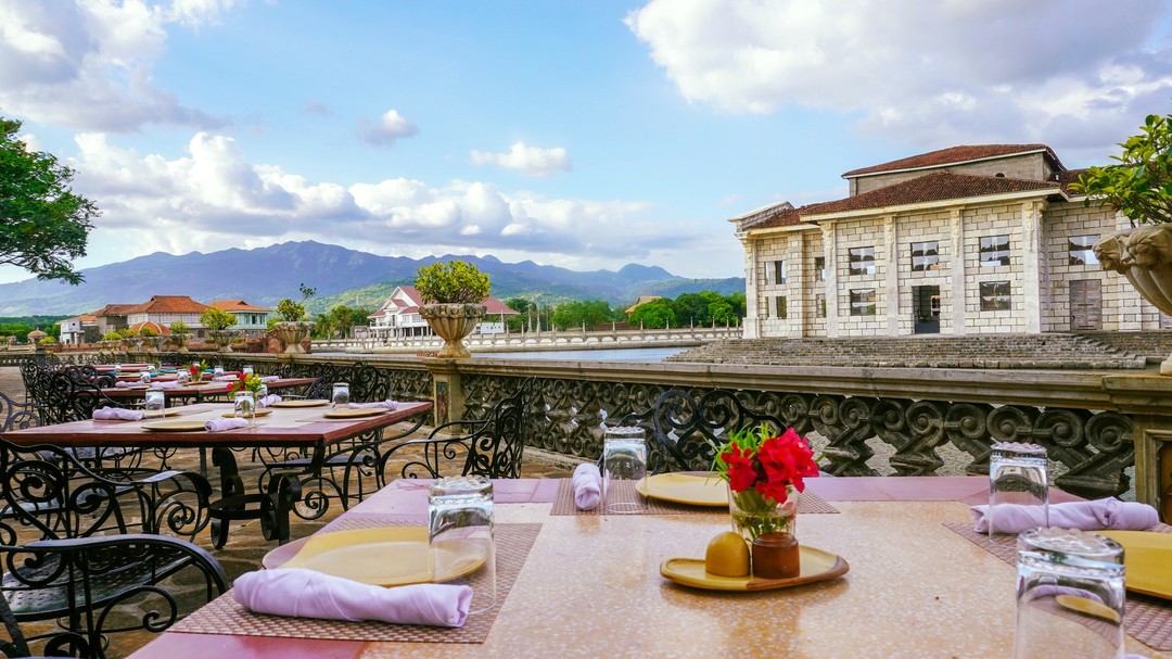 a table set up outside with a view of mountains and a river