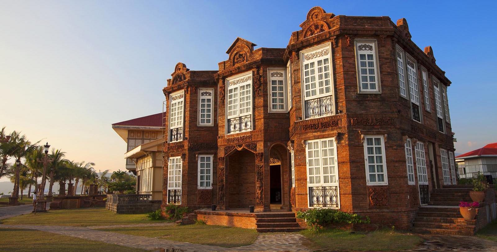 a brick building with a lawn and a blue sky