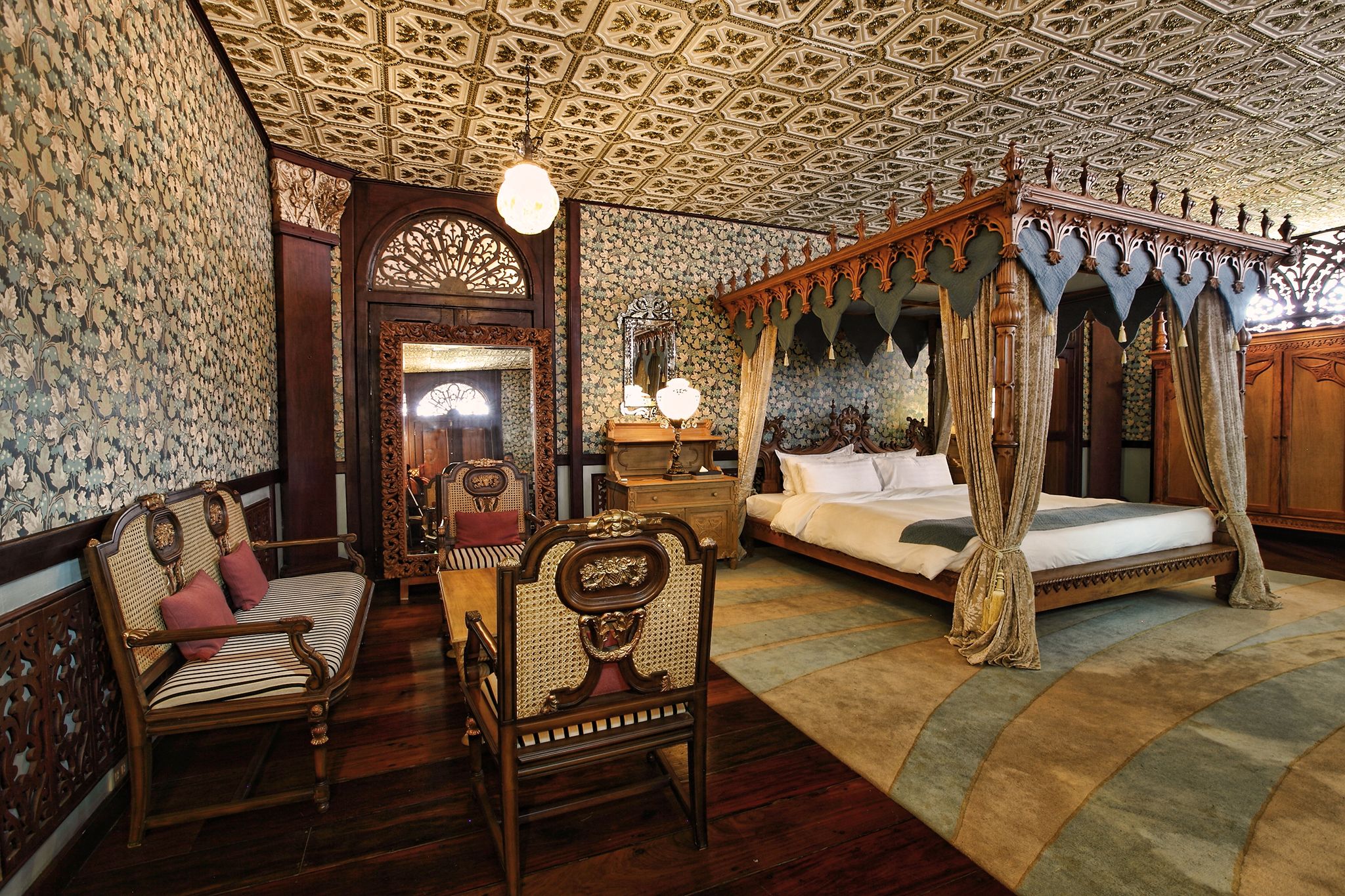 a room with a bed and chairs