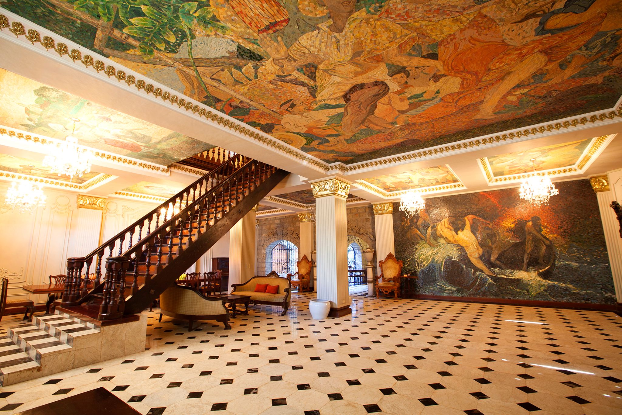 a room with a staircase and a mural on the ceiling