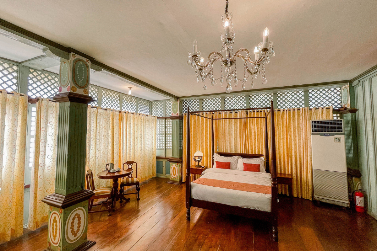 a room with a bed and a table and chairs