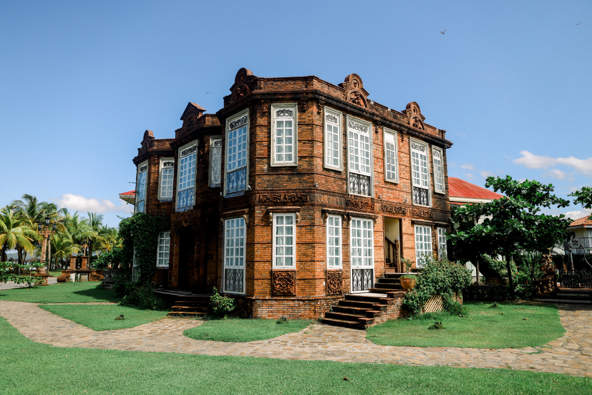 a brick building with a lawn and a path