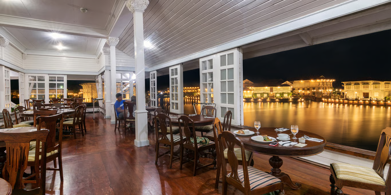 a room with a table and chairs and a view of the water