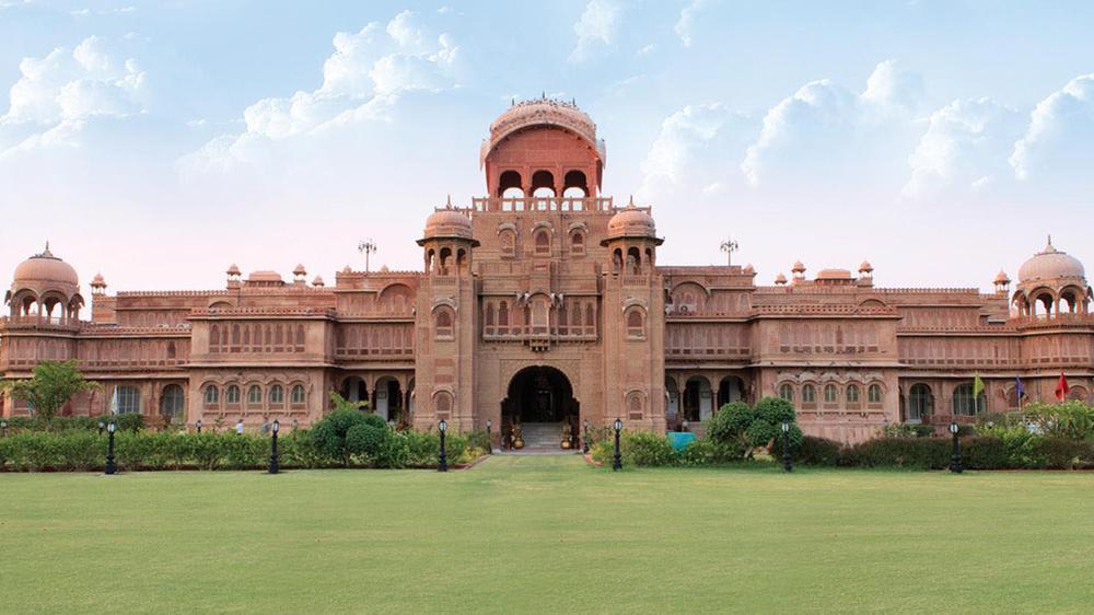 a large building with a lawn with Lahore Museum in the background