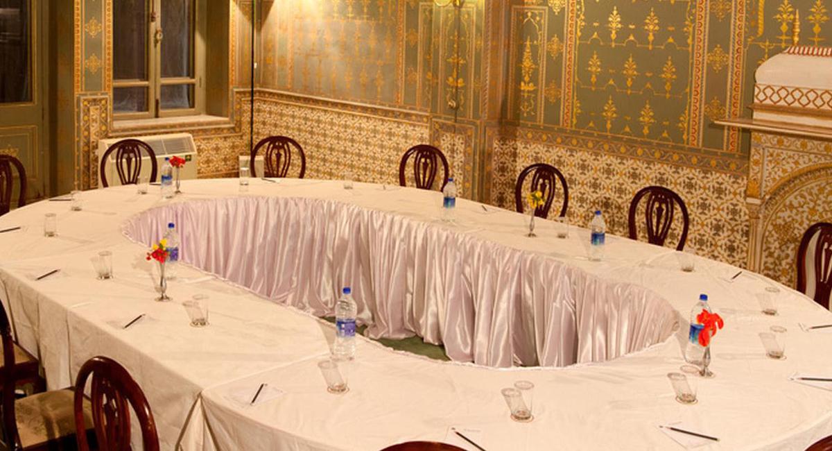 a long table with white tablecloths and water bottles