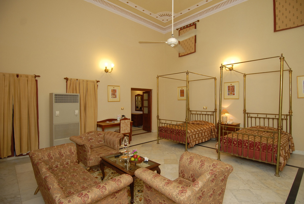 a room with two beds and a ceiling fan