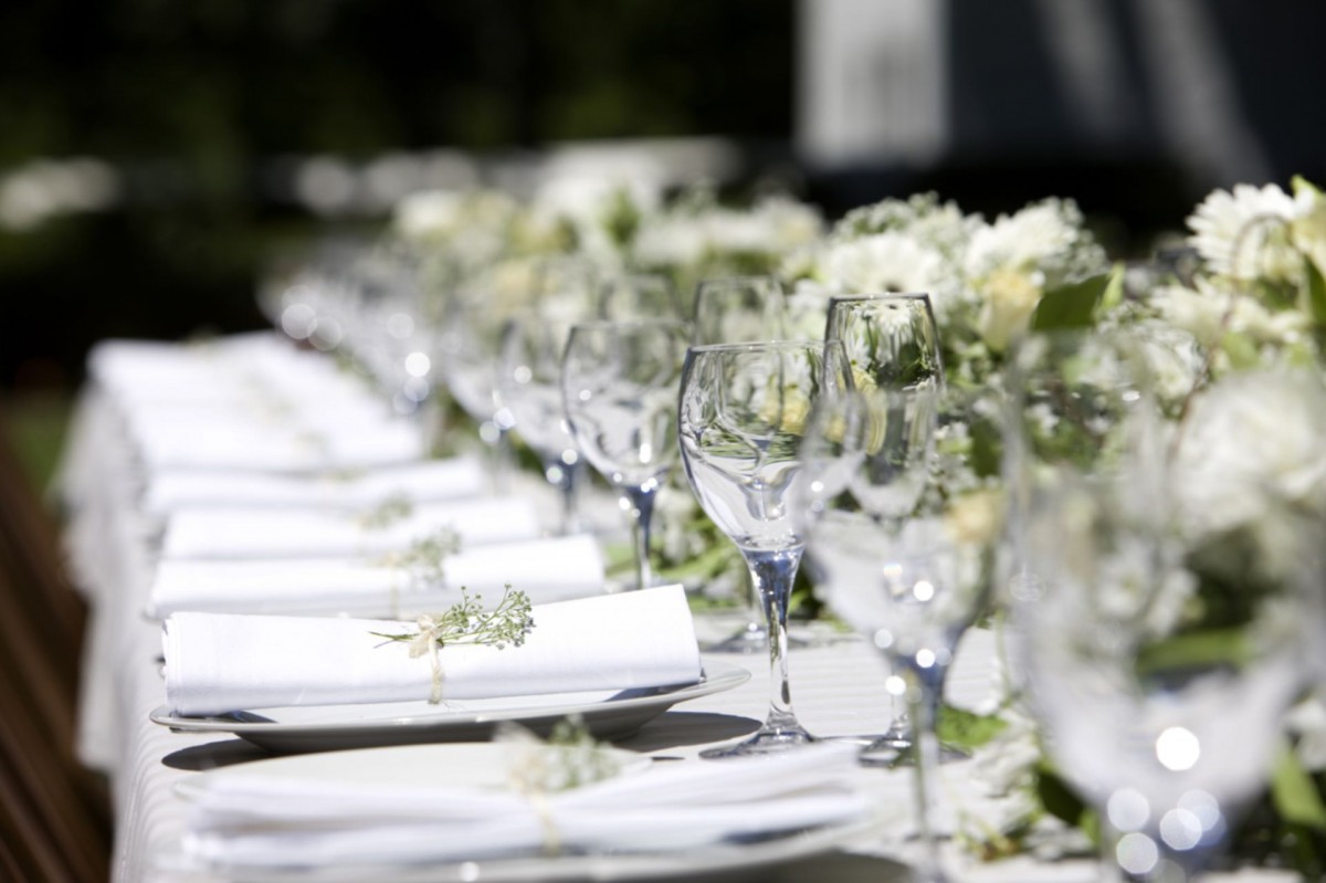 a long table with white plates and glasses