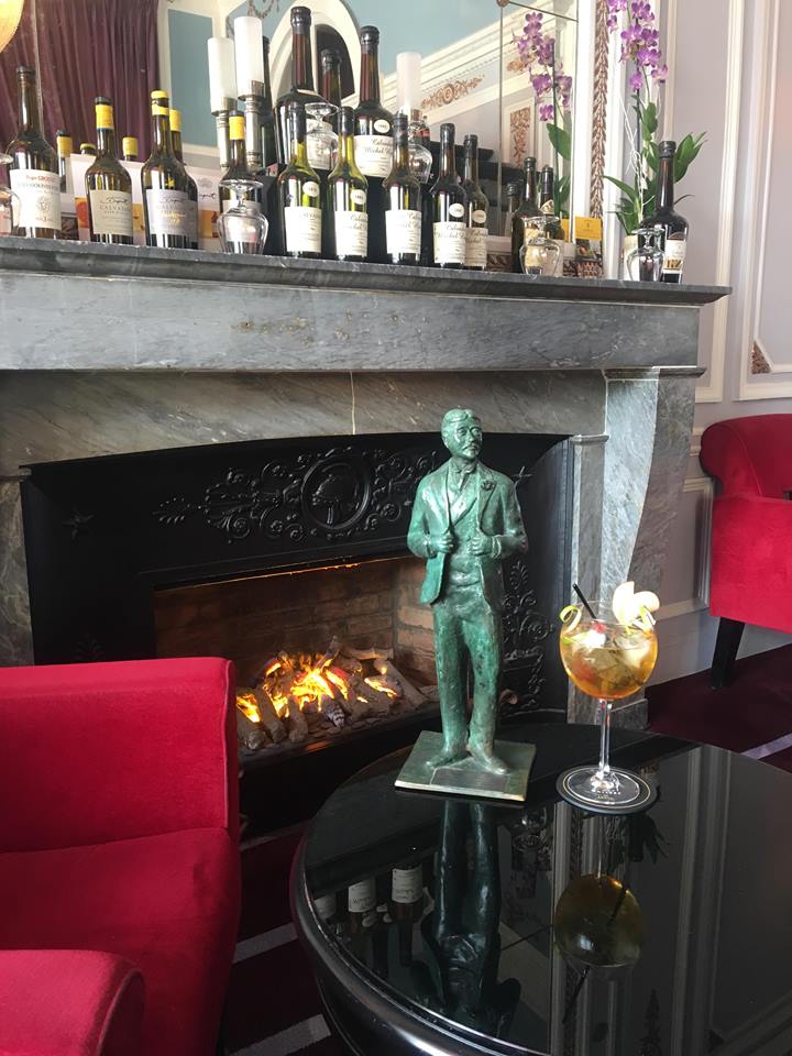 a fireplace with a statue and a drink on the table