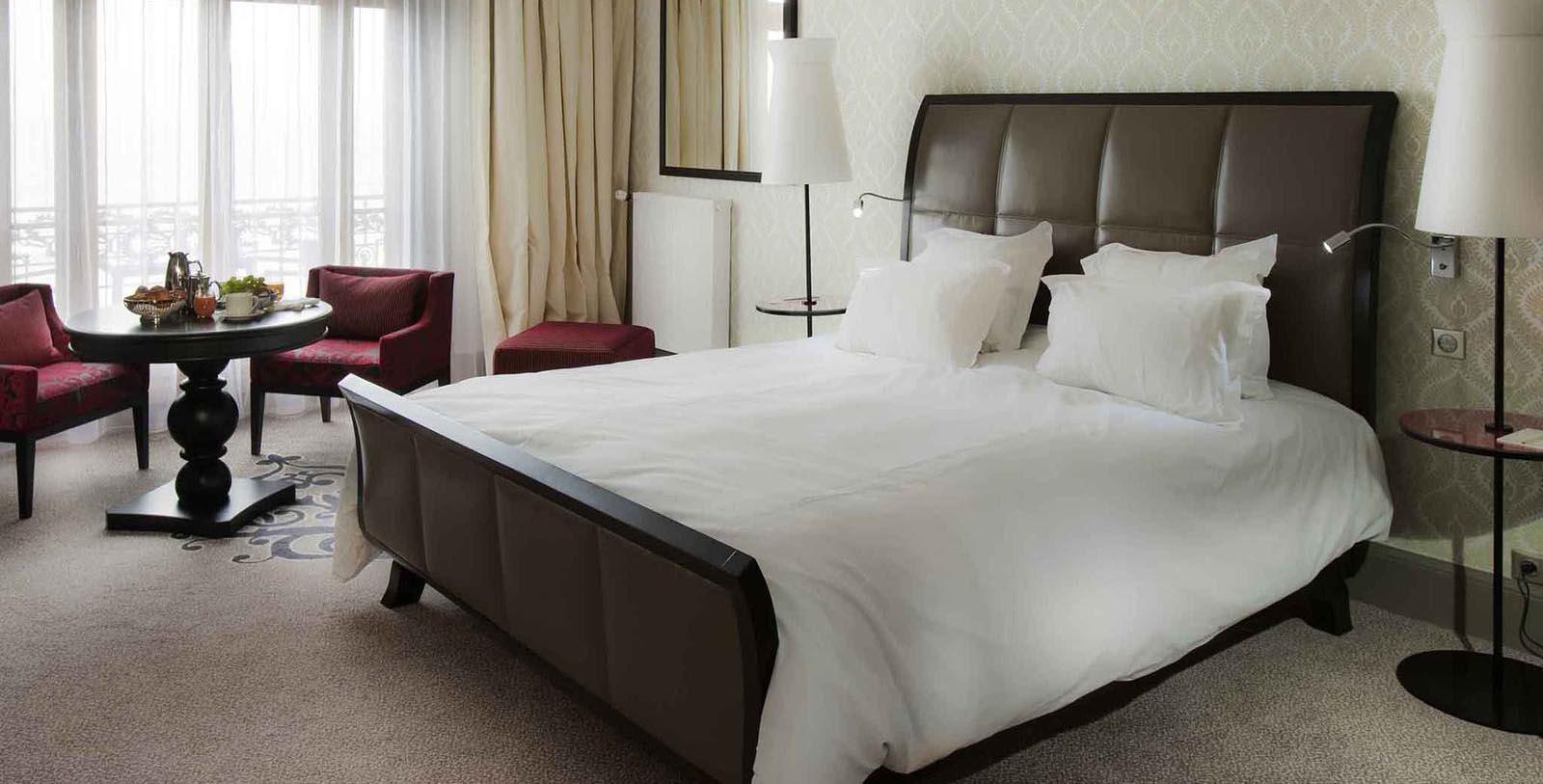 a bed with white sheets and pillows