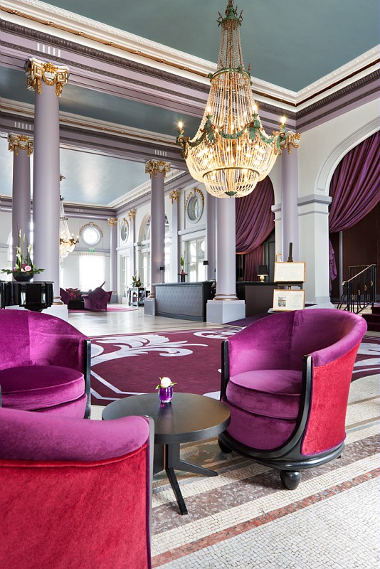 a room with purple chairs and a chandelier