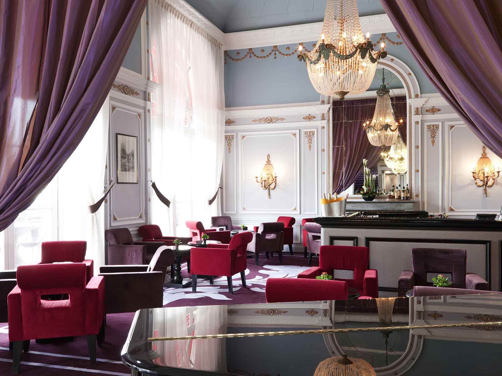 a room with red chairs and a chandelier