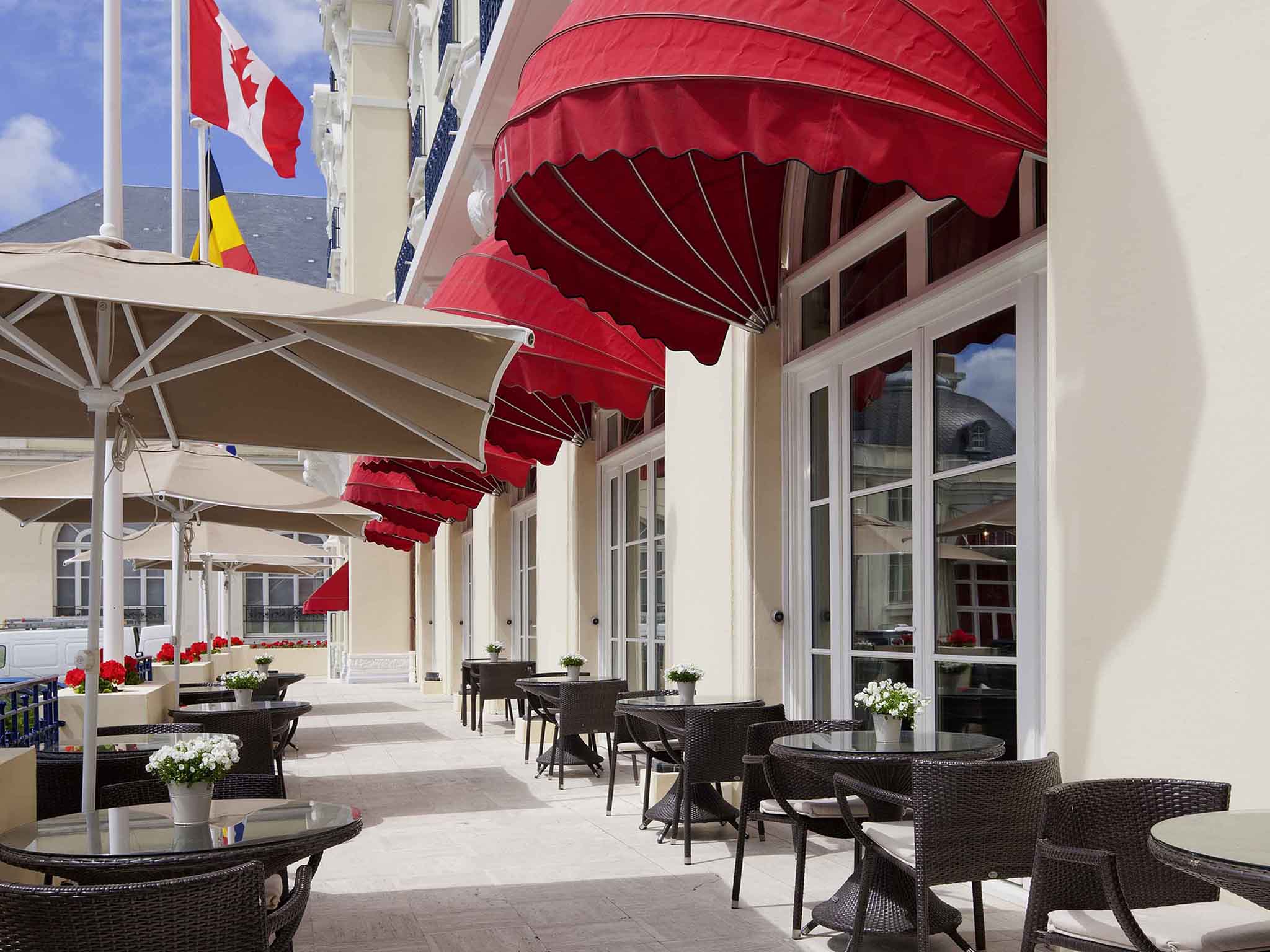a patio with tables and chairs and umbrellas