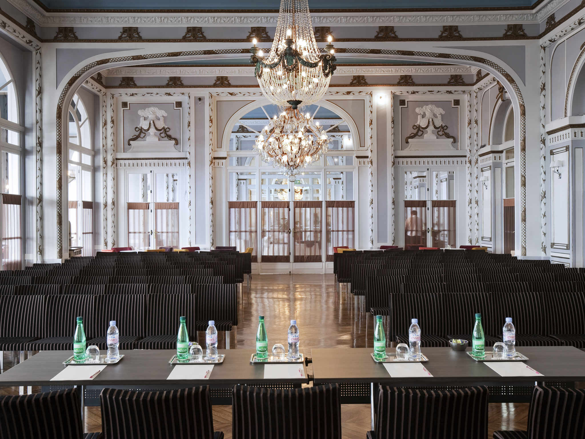 a room with chairs and tables and chandelier