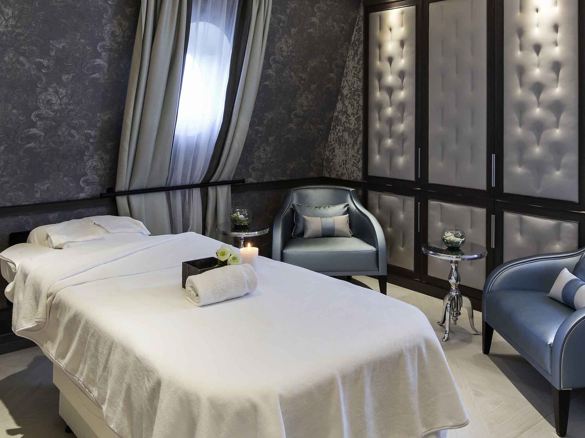 a room with a bed and chairs
