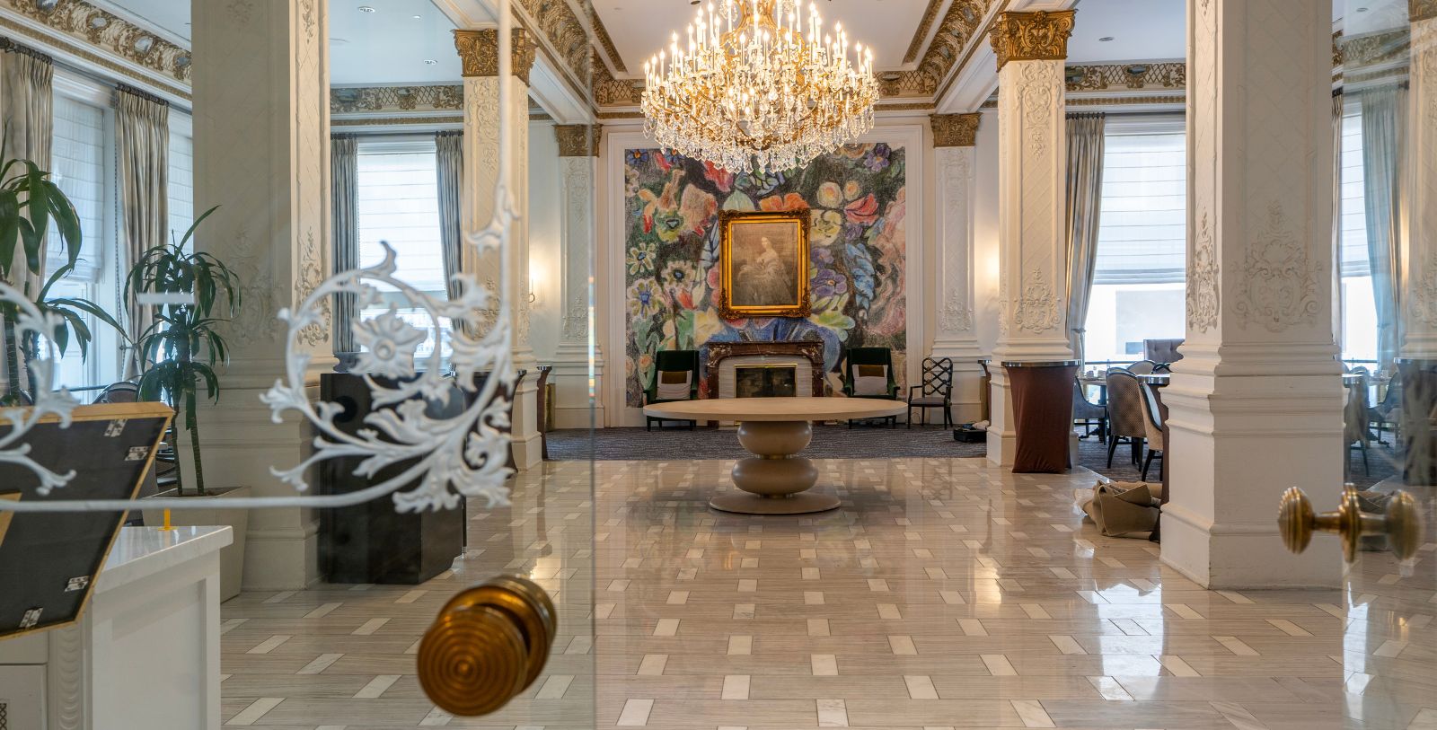 a room with a chandelier and a painting on the wall