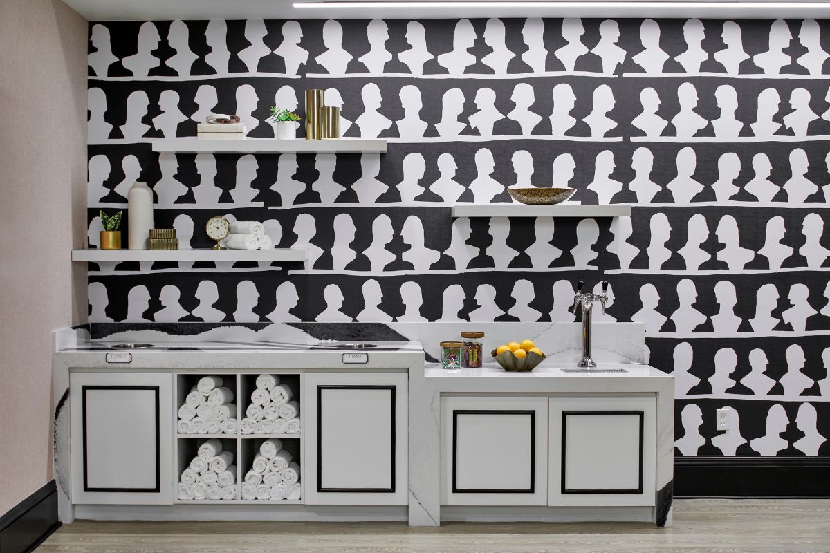 a room with white cabinets and black and white wallpaper