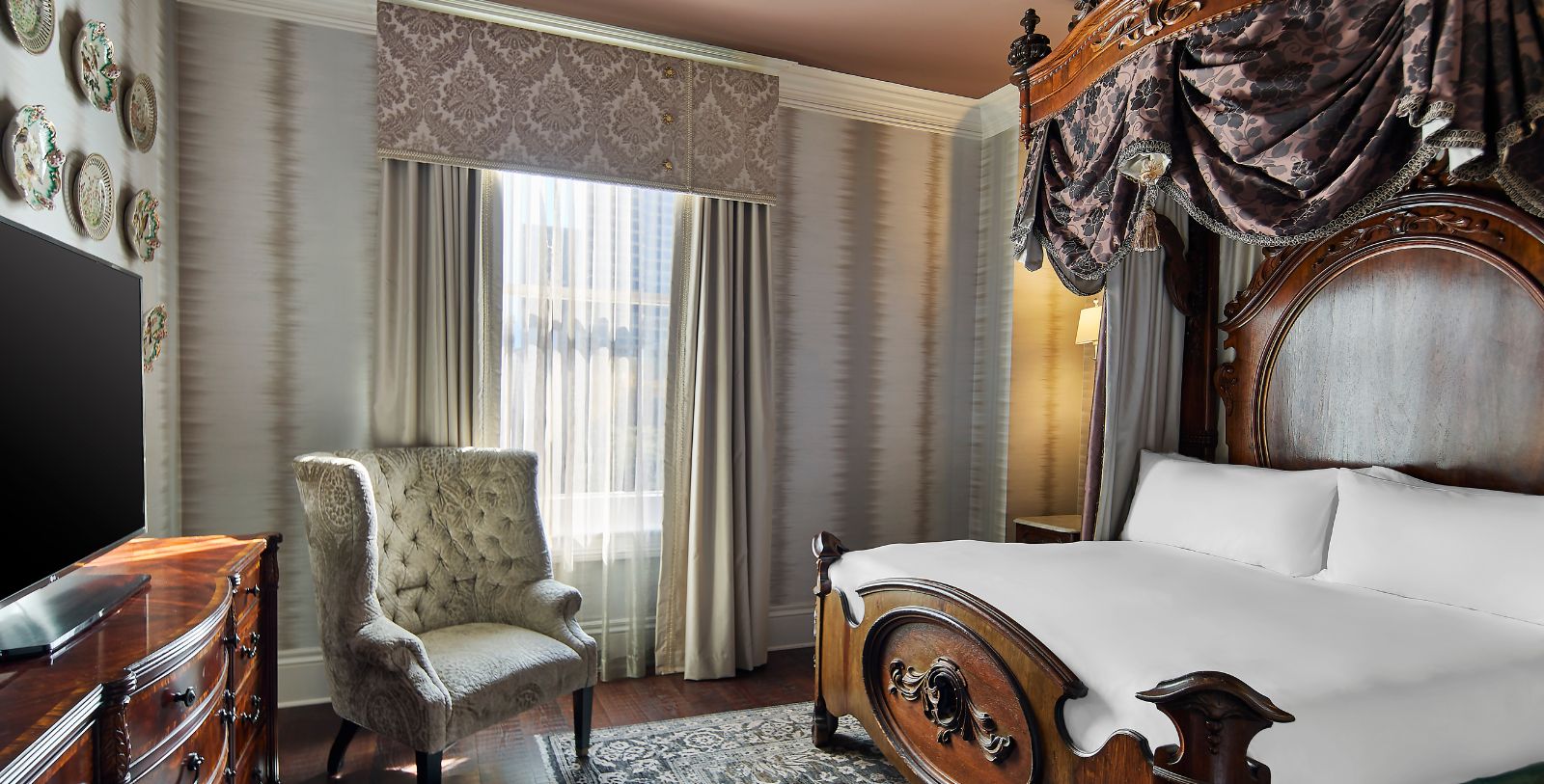 a bedroom with a canopy bed and a chair