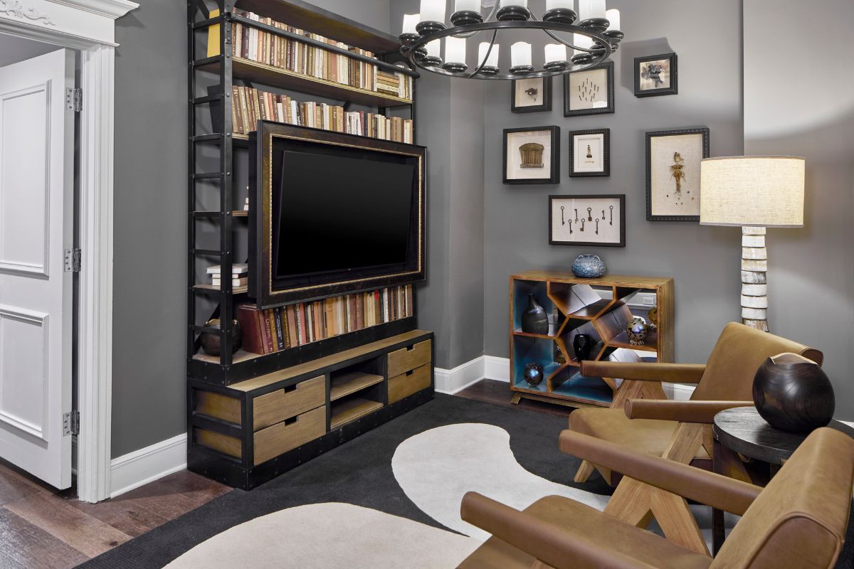 a room with a tv and bookshelf
