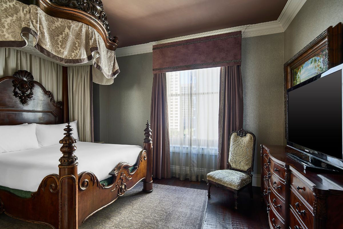 a bedroom with a canopy bed and a chair